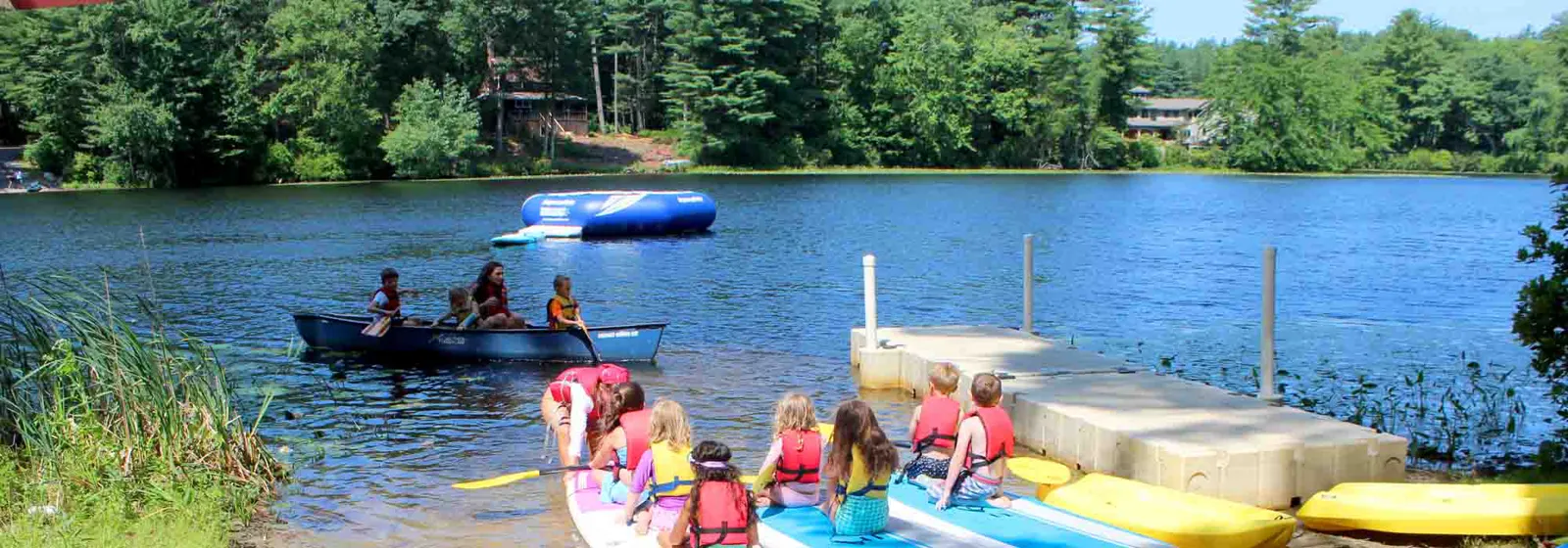 Campers canoeing and swimming at the Camp Sargent waterfront