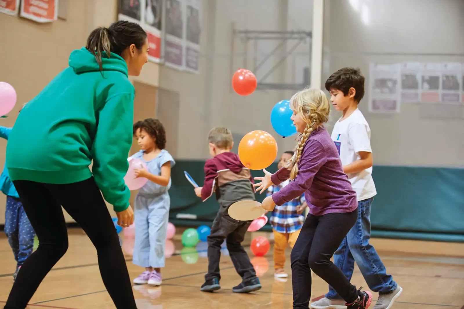 Kids playing with balloons in the gym at a birthday party