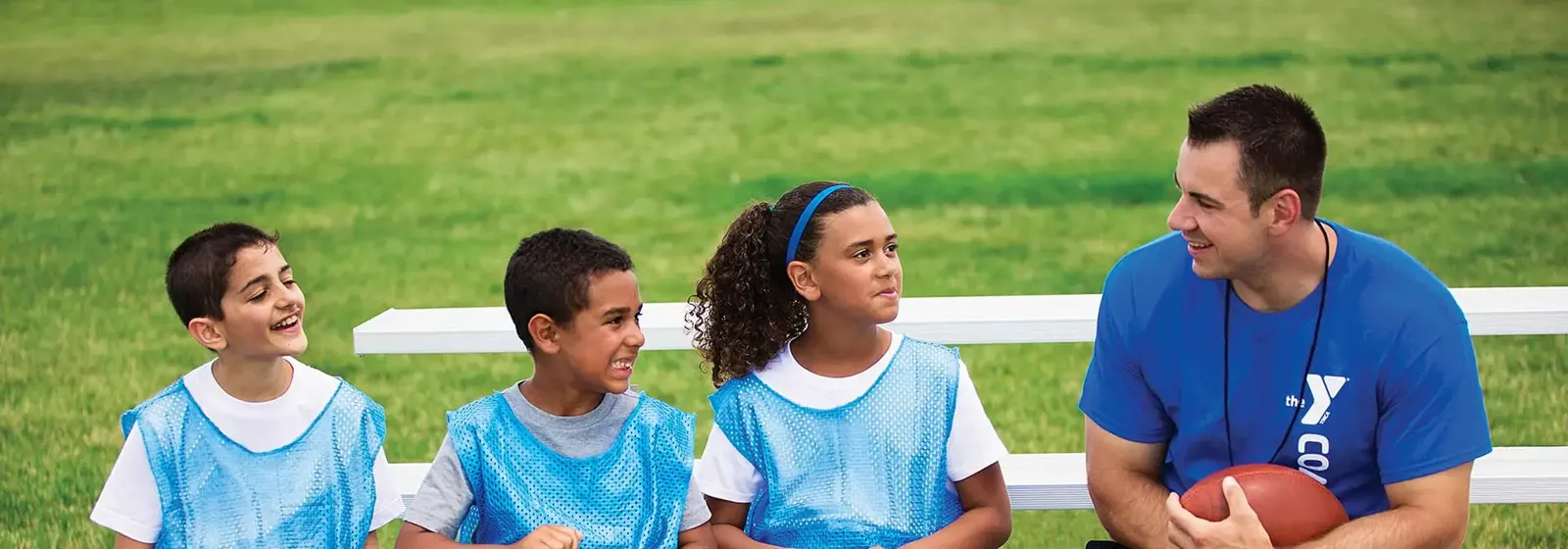 Coach talking with young athletes on a sports field