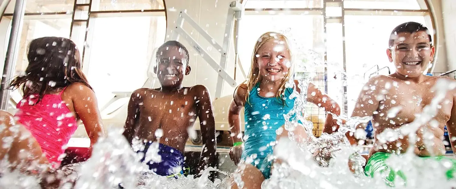 Kids splashing and laughing in the YMCA pool