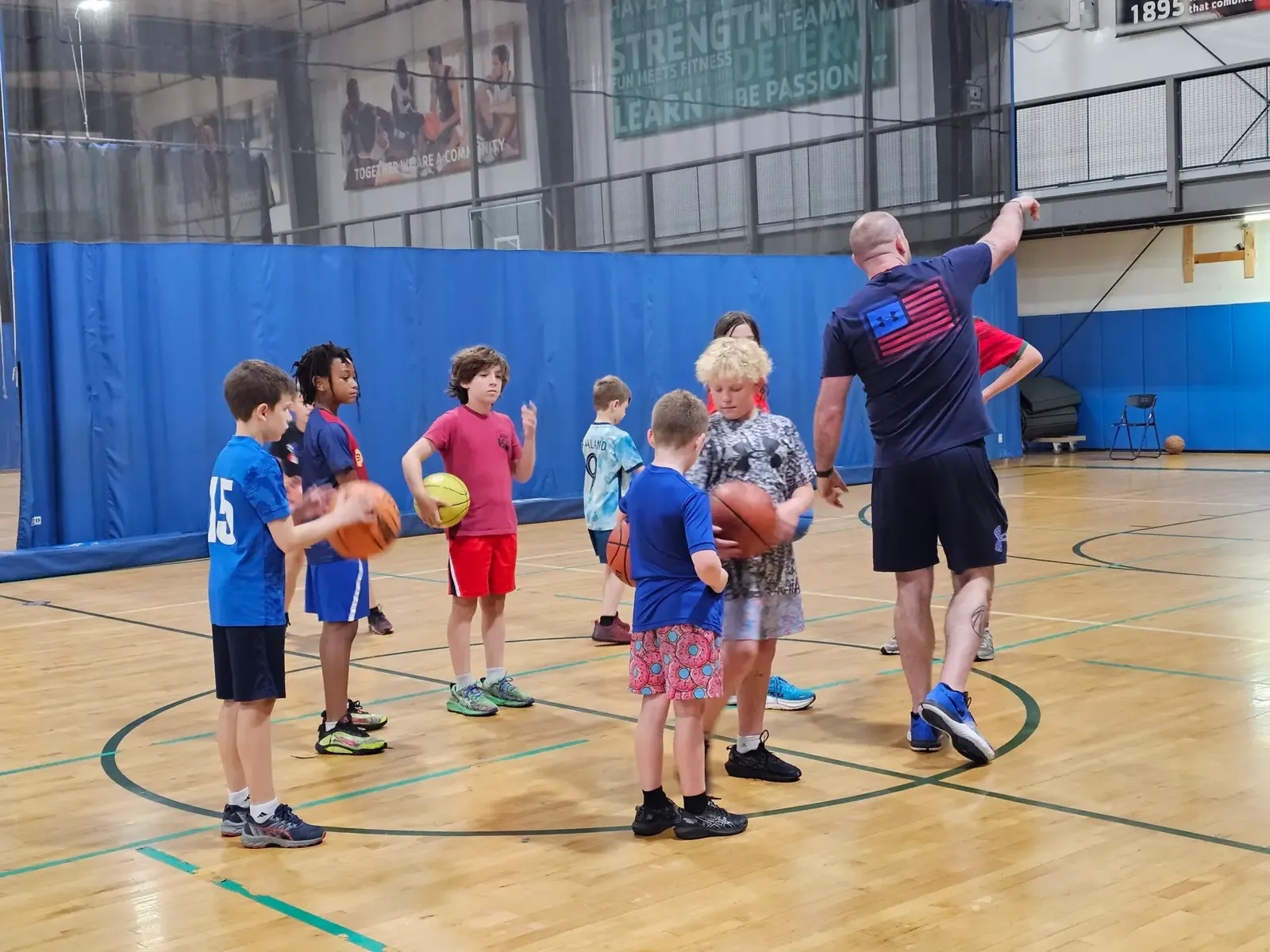 Coach leading a youth basketball practice in the gym